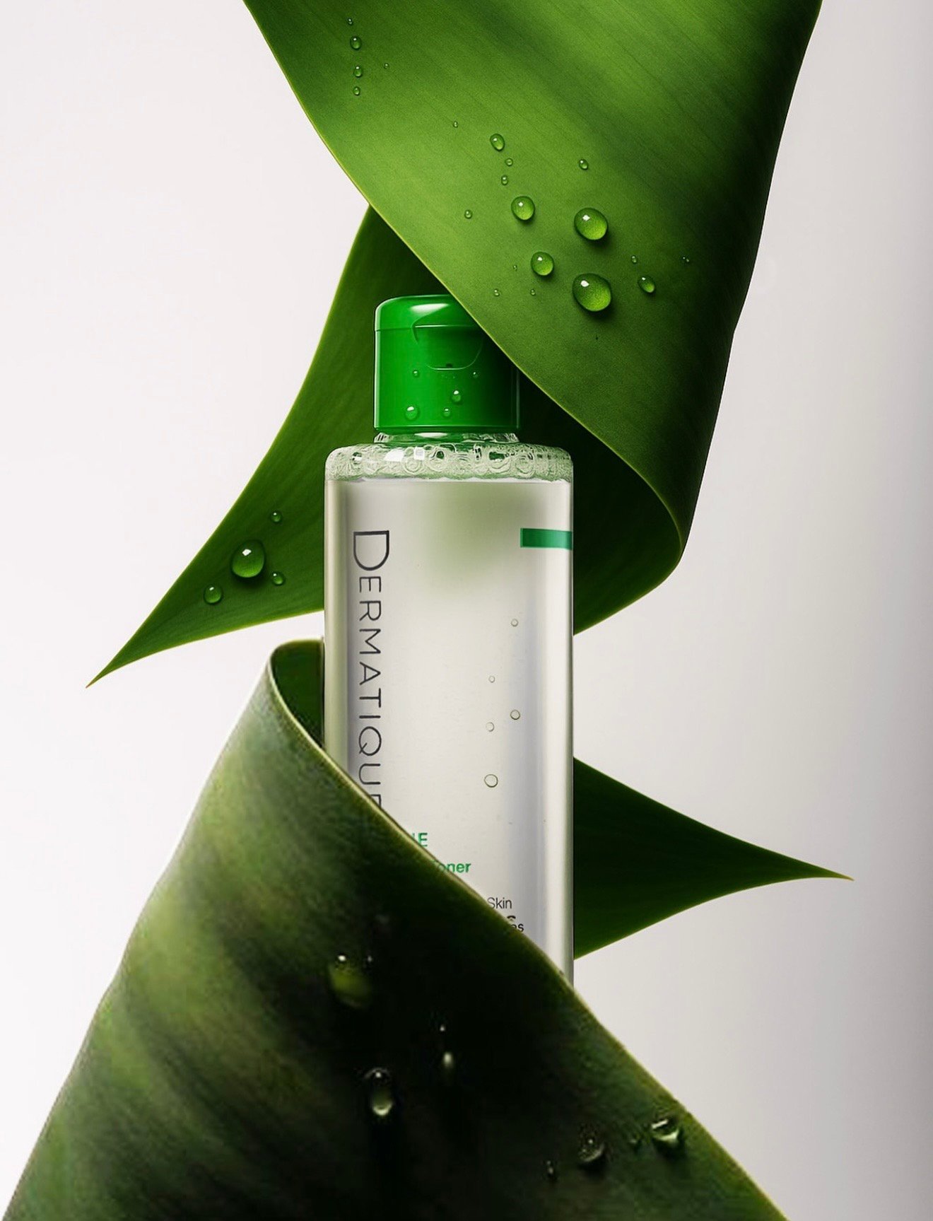 Dermatique toner wrapped in a green leaf